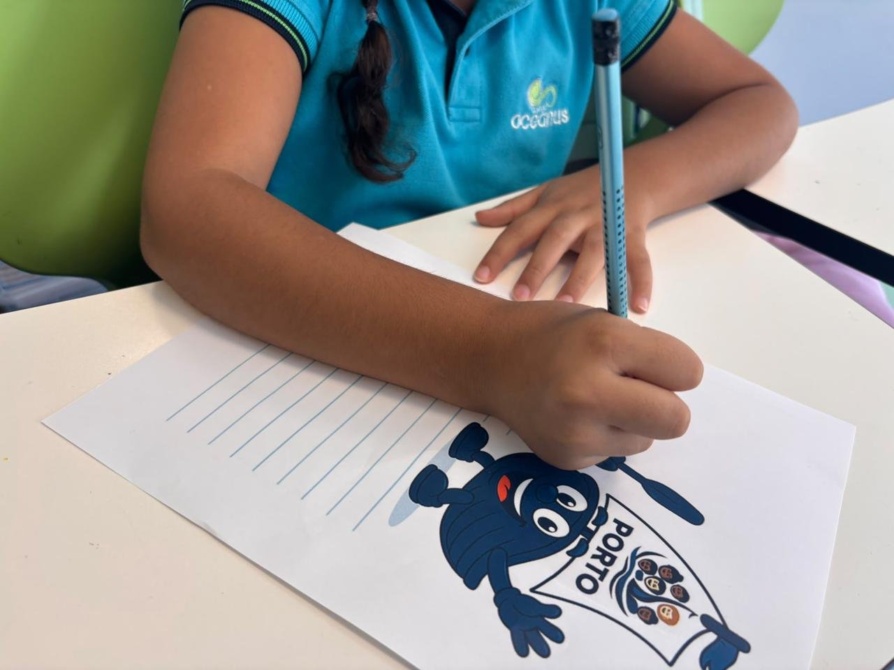 Aluna do Oceanus a escrever a sua Carta ao Douro, com o desenho da mascote do Congresso